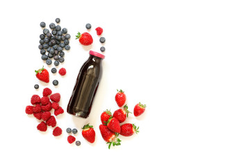 Bottle of strawberries, raspberries, blueberries juice isolated on white.