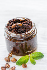 Body scrub of ground coffee on white table background