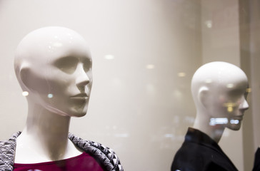 Two blurry female mannequins behind glass