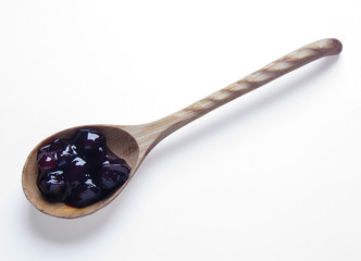 Cherry jam in wooden spoon isolated on white background