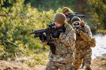 Fototapeta premium team of special forces weapons in cold forest. Winter warfare and military concept
