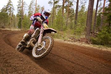 Motocross driver accelerating the motorbike on the race track