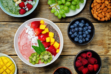 Strawberry smoothies breakfast bowl with coconut flakes, mango, strawberry and Chia seeds