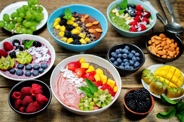 Variation of healthy smoothie breakfast bowls with berries, fruits and nuts
