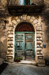 Fototapeta na wymiar Old village Badolato in Italy. Ancient green patina door.