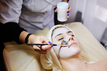 Beautiful girl doing cosmetic procedures. Cosmetology. Spa, facial skin care