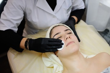 Beautiful girl doing cosmetic procedures. Cosmetology. Spa, facial skin care