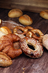 Different kinds of bread and bread rolls on board from above. Ki