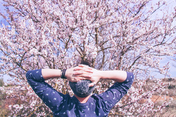 Hombre hipster frente a un árbol en flor en primavera © nanihta