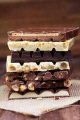 Chocolate bars on a wooden background with chocolate tower