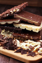 Chocolate bars on a wooden background with chocolate tower