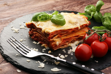 Serving of spicy traditional Italian beef lasagne in a restaurant - bolognese sauce topped with...
