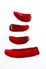 Texture of liquid red lipstick  on white background. Four strokes