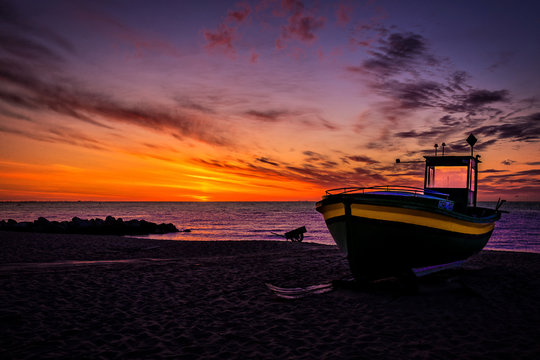 Fototapeta Wschód słońca z widokiem na morze i kuter