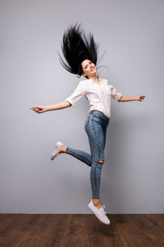 Successful happy pretty woman isolated on grey background jumping up