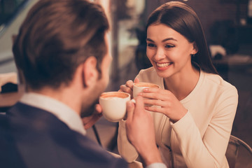 Happy romantic couple sitting in a cafe with coffee