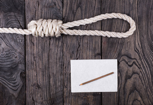 A rope for hanging and a suicide note on an old wooden table,Loop lynch,
