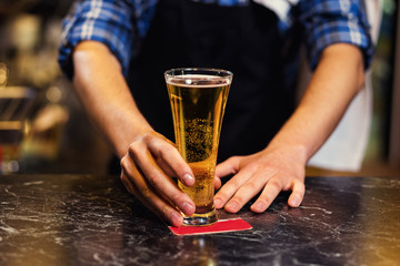 Bartender pouring the fresh beer in pub,barman hand at beer tap pouring a draught lager beer,beer from the tap,Filling glass with beer,fresh beer,pub.Bar.Restaurant.European bar.American bar.