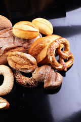 Different kinds of bread and bread rolls on board from above. Ki