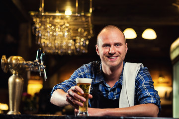 Bartender pouring the fresh beer in pub,barman hand at beer tap pouring a draught lager beer,beer from the tap,Filling glass with beer,fresh beer,pub.Bar.Restaurant.European bar.American bar.