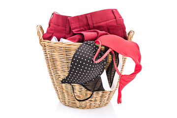 Clothes in a laundry wooden basket isolated on white background