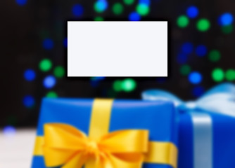Business card mockup. Gift boxes on blurred background. Presents wrapped with paper, bow and ribbons. Christmas or birthday packages.