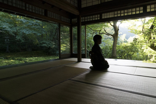 Person meditating in temple, Kyoto, Japan