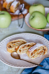 Apple strudel (pie) with raisins, walnuts and powdered sugar.