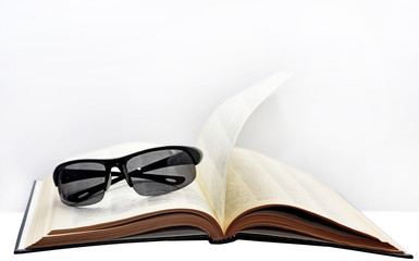 Open book with glasses.