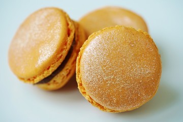 Colorful round macaron cookies with gold dust on a white platter