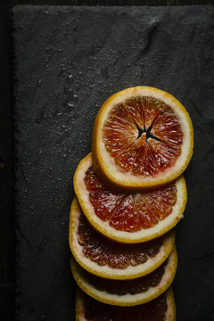 Slices of blood orange on slate