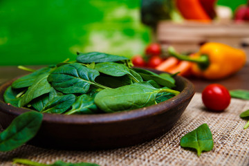 Spinach leaves in bowl. Raw fresh vegetable. Fresh natural plant leaf. Organic bio food on rustic wooden table.