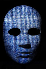 Textured mask with blue jean painted surface, neutral expression on dark background.