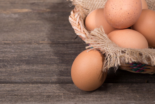 Brown Eggs in a Basket on a Weathered Wooden Background