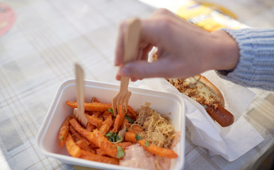 close up of hand with hot dog and sweet potato