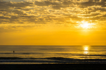 Man Paddle Surfing at Sunrise