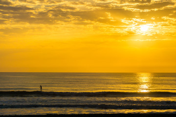 Man Paddle Surfing at Sunrise