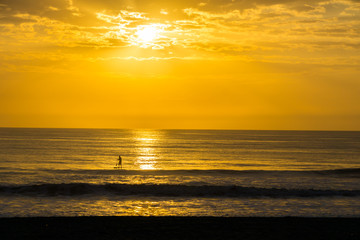 Fototapeta premium Man Paddle Surfing at Sunrise
