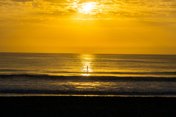 Man Paddle Surfing at Sunrise