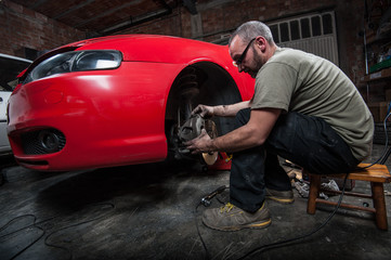 Fototapeta na wymiar mechanic fixing a car at home