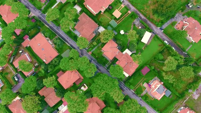 Shooting from the helicopter of modern suburban everyday life, houses with fenced areas, lawns and beautiful trees, aerial shot