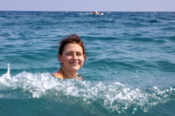 One Caucasian teen girl floundering in the sea water.