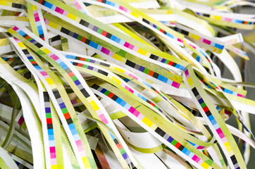 Prepress color management in print production. CMYK color stripes cut on printed paper. Quality...