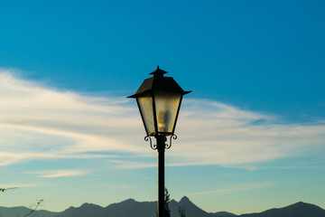 Head of an old fashioned style lamppost against a blue sky