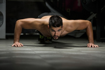 Fototapeta na wymiar Men doing pushups in gym