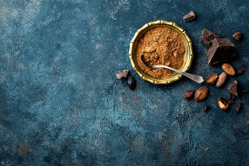 Cocoa powder, beans and dark chocolate pieces crushed, culinary background, top view