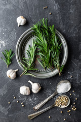 Rosemary, garlic, salt and white pepper, culinary background with various spices, directly above, flat lay