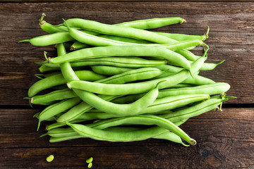 Fresh green beans on dark wooden rustic background top view flat lay