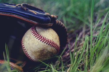 Old rugged baseball in glove to play the sport.  Red seams showing against white leather.  Great athletic background for ball players or coaches.