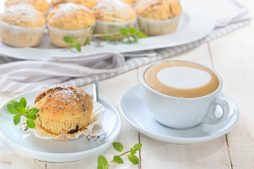 Stracciatella-Bananen-Muffins mit Cappuccino -Freshly baked chocolate banana muffins with a cup of cappuccino